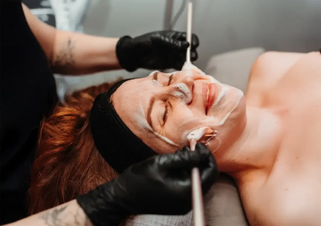 Aesthetician of the Month December 2025 Lauren Hybels performing a double brush technique on client.